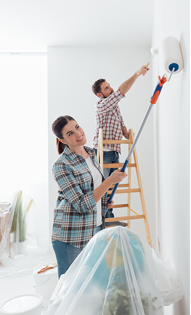 Mann und Frau streichen Wand