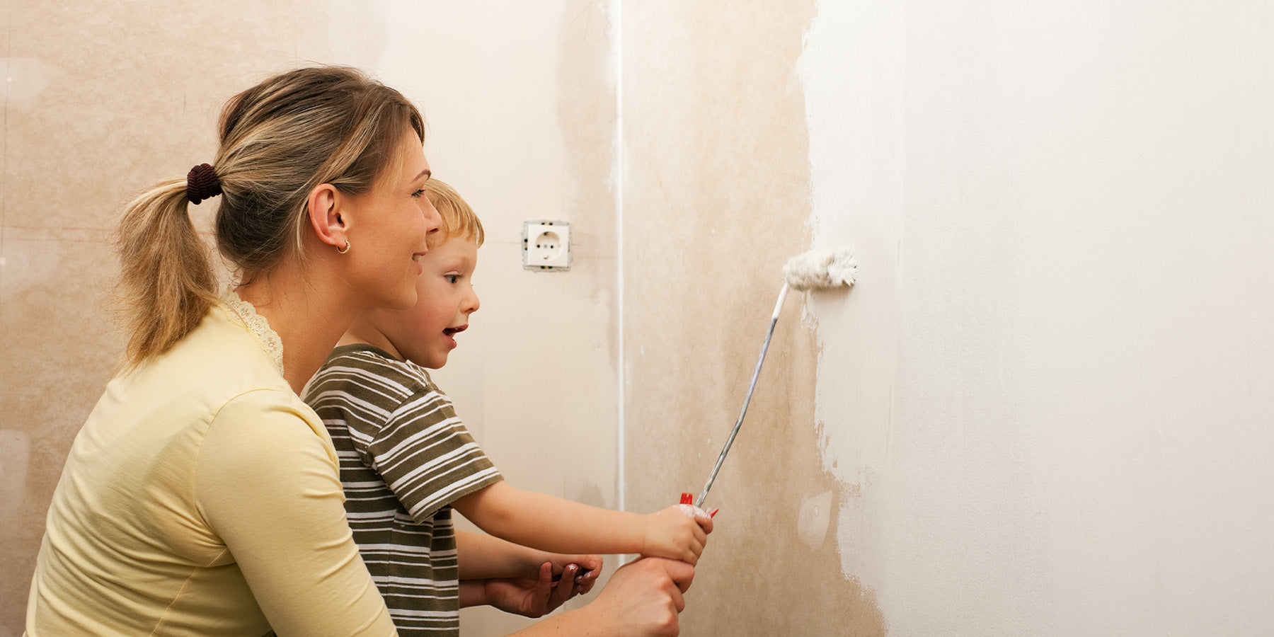 Mutter und Kind streichen Wand